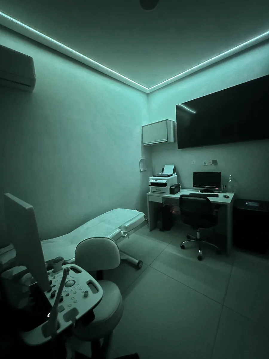 Sala de ultrassom com estação de trabalho e maca de exame