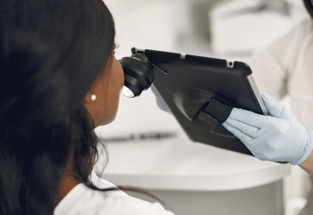 Dermatologista examinando a pele do paciente com dermatoscópio