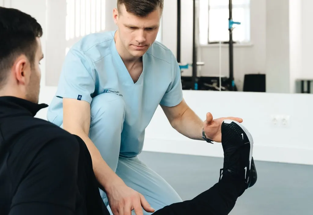 Fisioterapeuta alongando a perna do paciente em clínica
