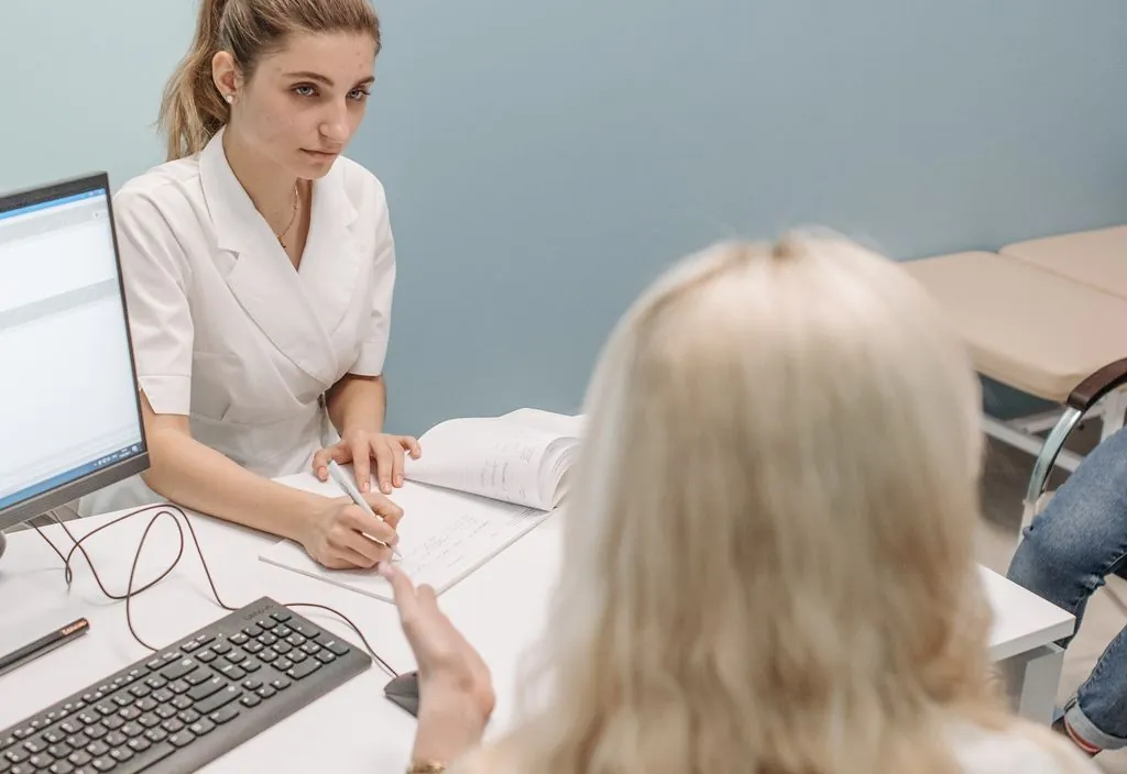 Médica em consulta orientando o paciente sobre o exame