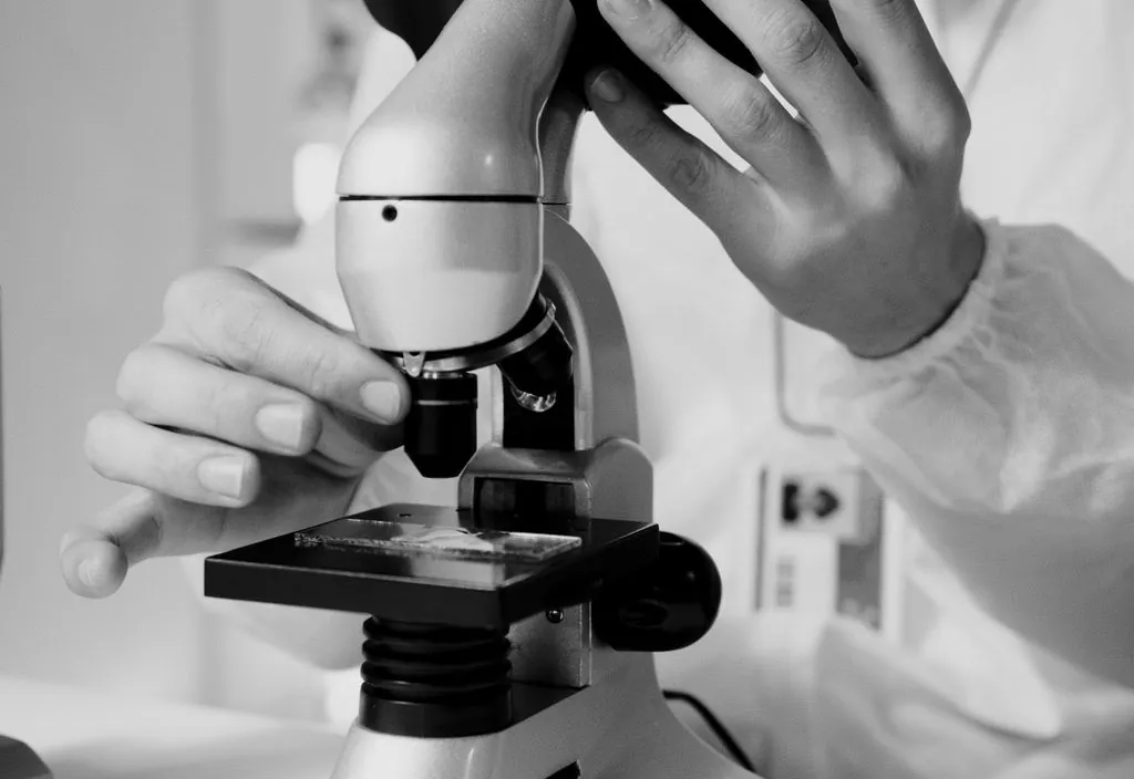 Profissional analisando amostras em microscópio