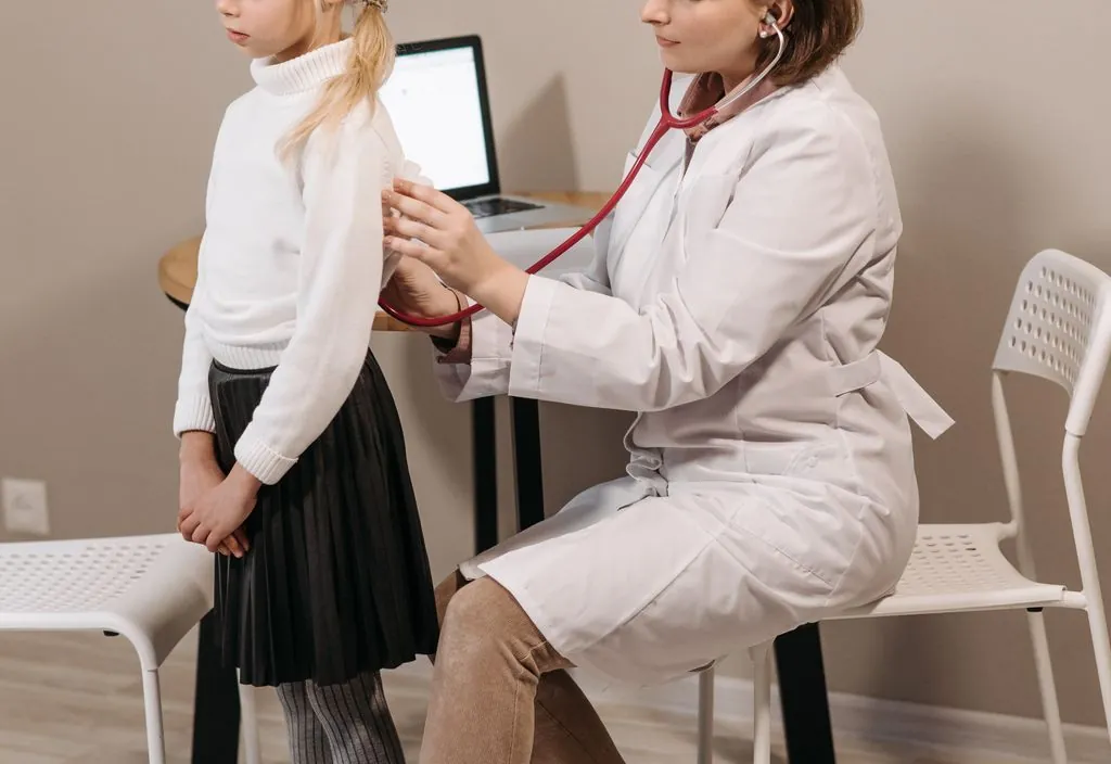 Pediatra em consulta de rotina com criança
